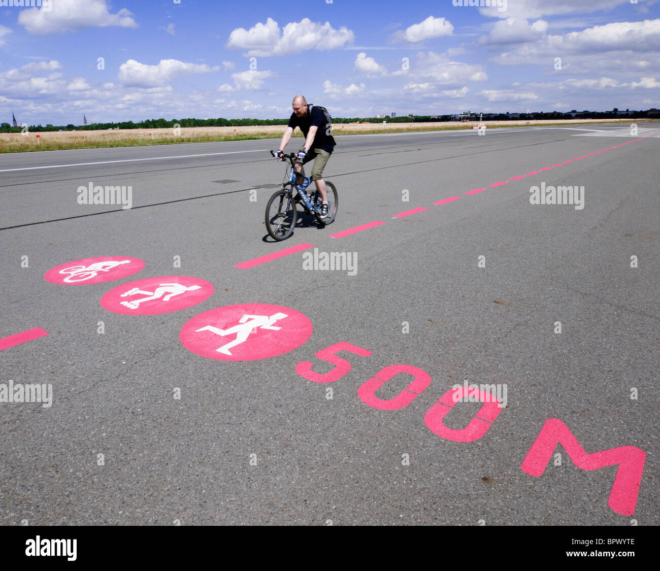 Pista ciclabile sulla ex pista di nuova città pubblico Tempelhofer Park sul sito del famoso ex aeroporto Tempelhof di Berlino Germania Foto Stock