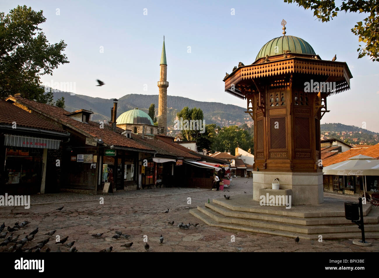 Una piazza di Sarajevo della vecchia città nel quartiere Bascarsija, mostrando il Sebilj e il minareto di Gazi Husrev-beg moschea Foto Stock
