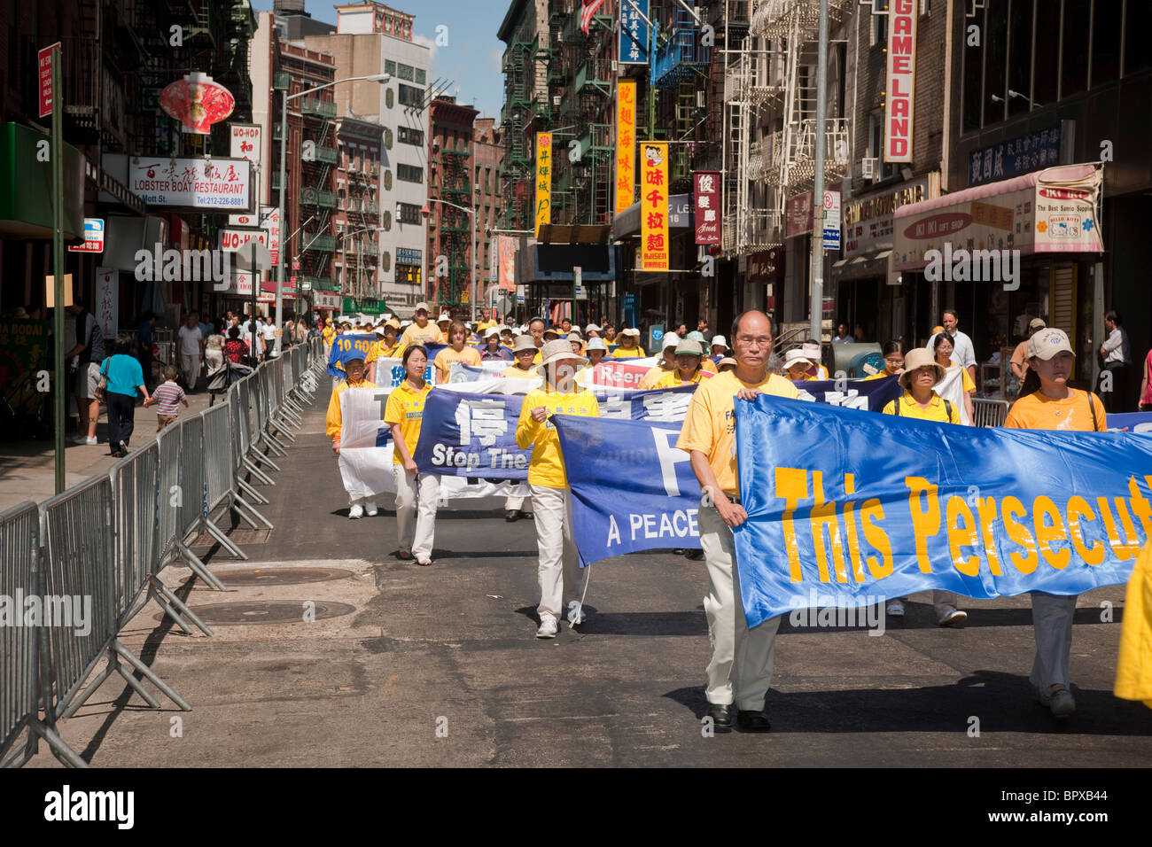 I membri della setta Falun Dafa (Falun Gong) provenienti da tutto il mondo sfilano per le strade di Chinatown in New York Foto Stock