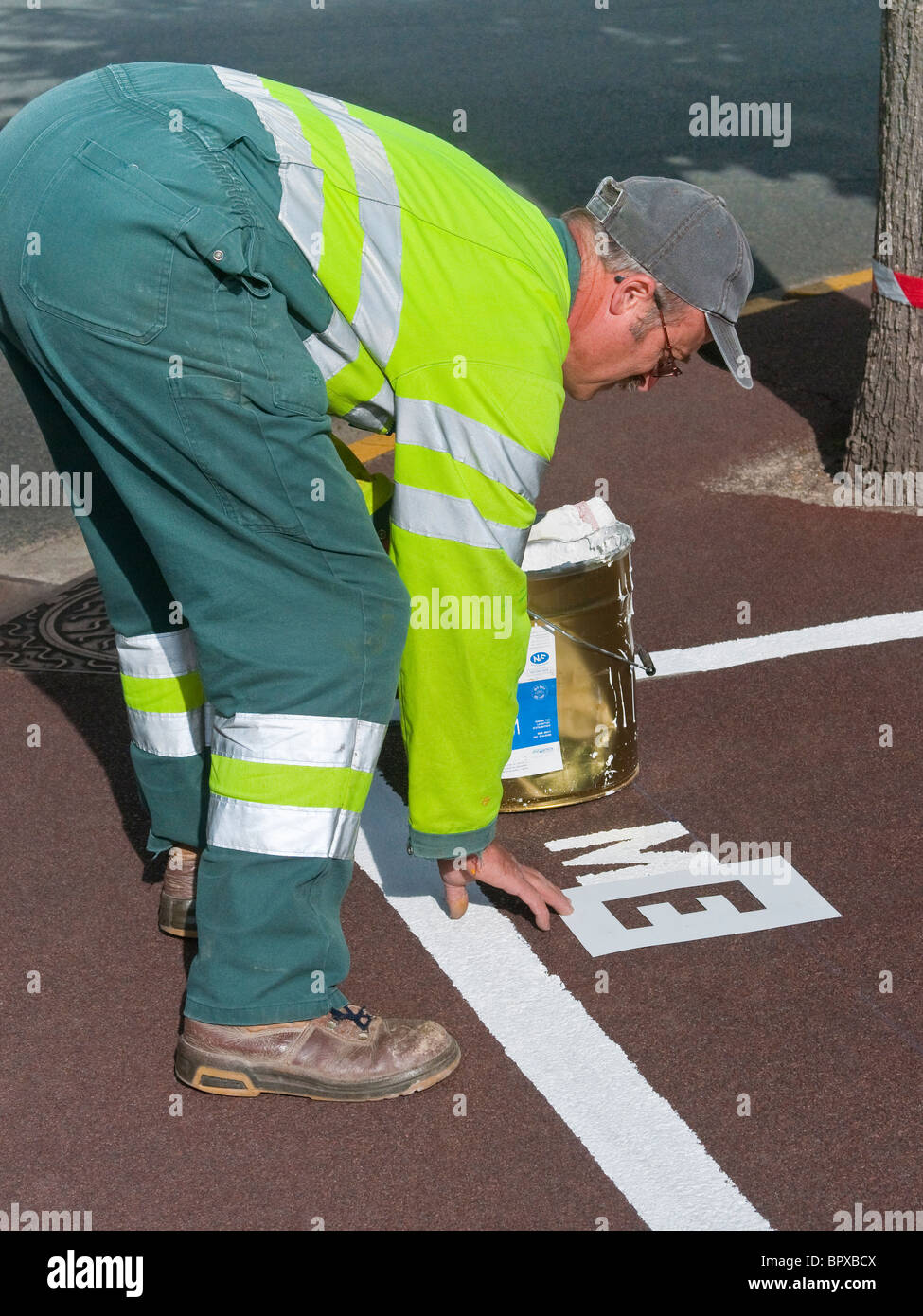 Consiglio lavoratore lettera di smistamento stencil per la verniciatura di informazioni sulla superficie stradale - Francia. Foto Stock