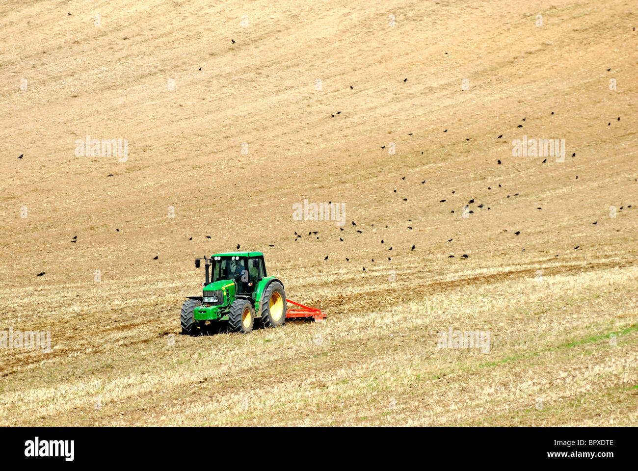 Aratura del trattore sul campo il Surrey Hills ,l'Inghilterra Foto Stock