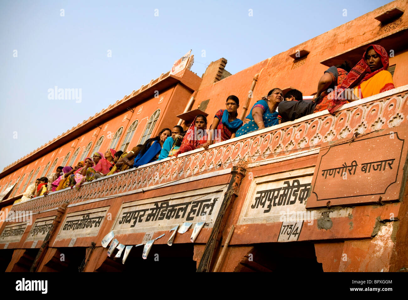 Popolo Indiano su una terrazza che guarda la parata durante il Festival di Gangaur, Jaipur, Rajastan, India. Foto Stock