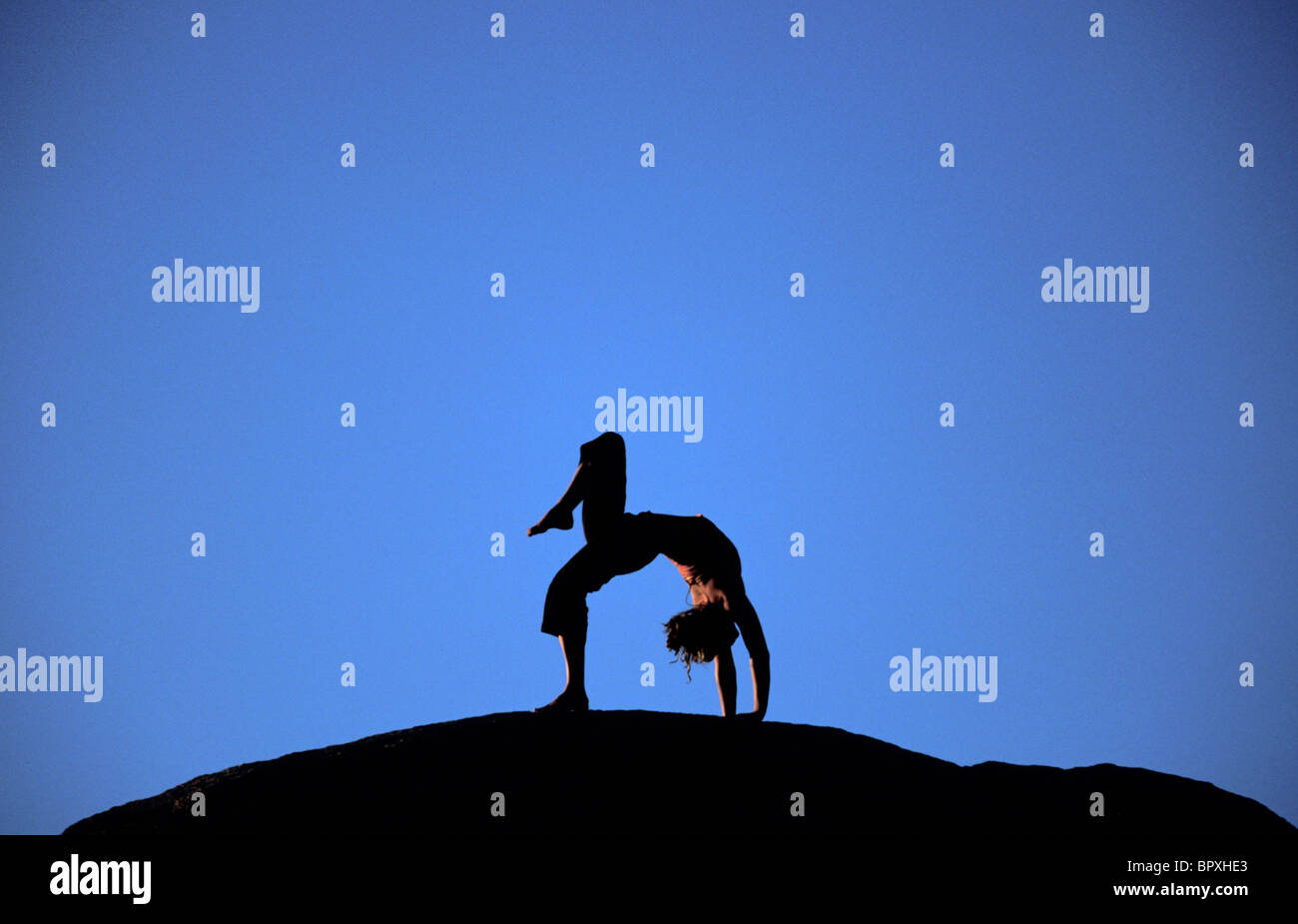 La donna a praticare lo yoga al di fuori. Granello di polline di massi, Vescovo, California. Foto Stock