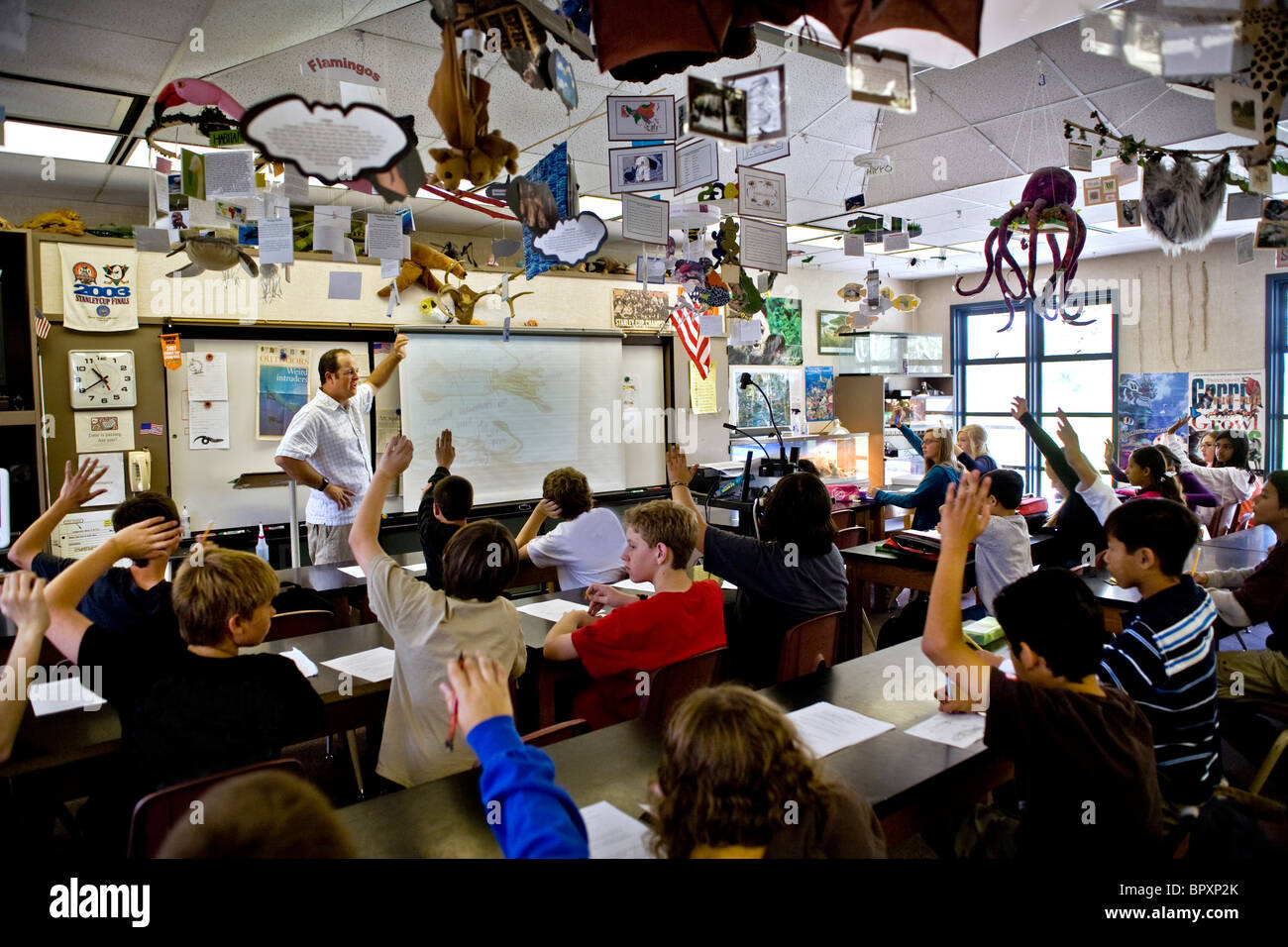 Gli studenti' mani go up come una scuola media insegnante di scienze pone una domanda aliso viejo california usa Foto Stock