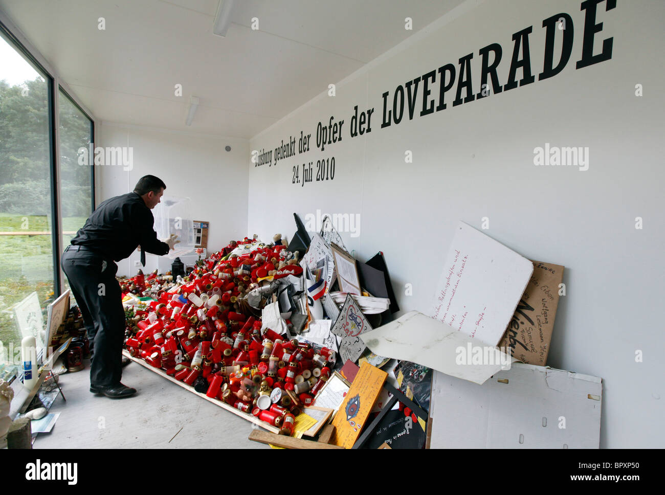 Duisburg Loveparade 2010: cubo di vetro presso il sito della tragedia in cui il dolore dei regali, candele e giocattoli sono mantenuti da ricordare Foto Stock