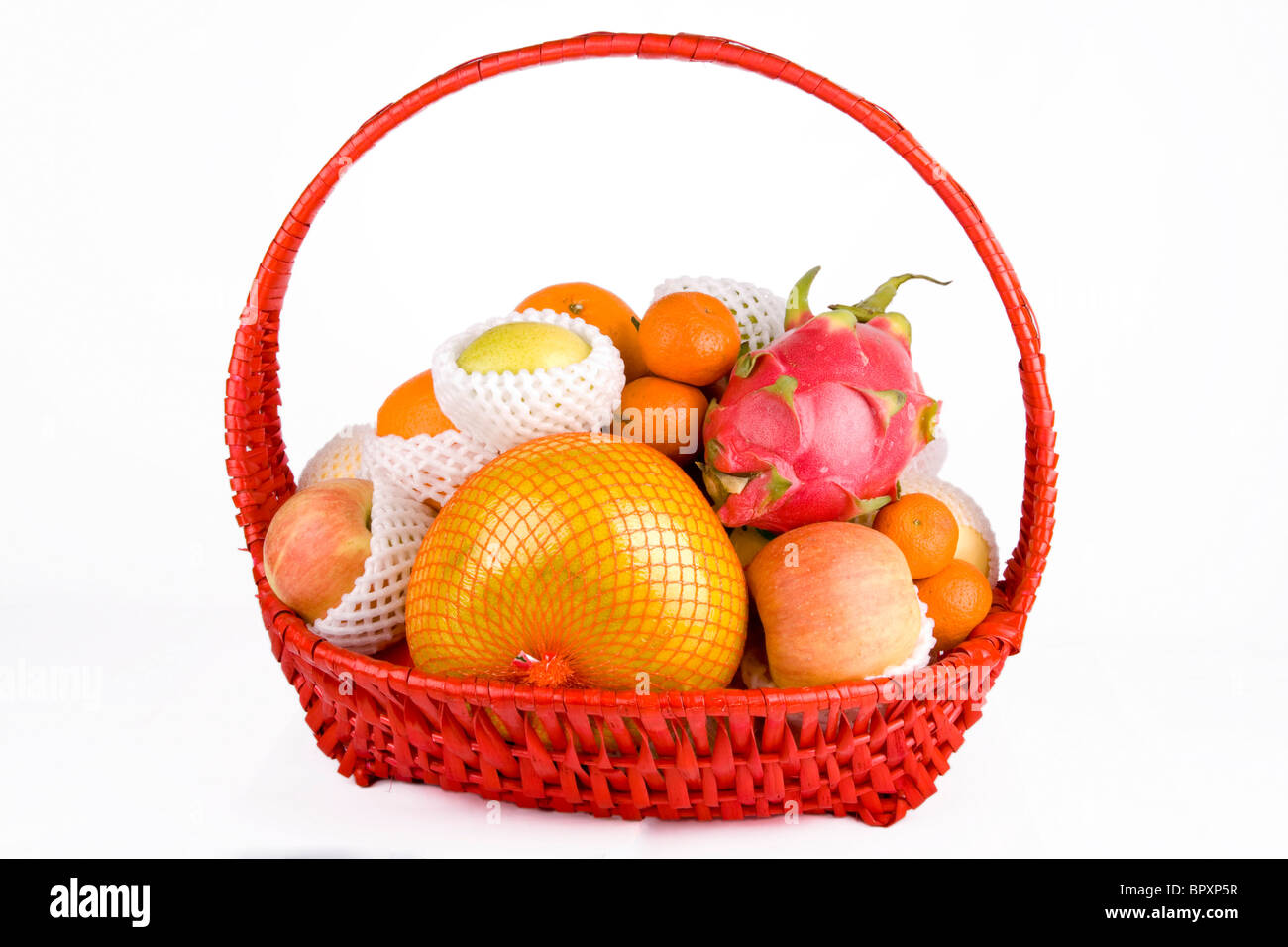 Cesto di frutta con frutta mista su sfondo bianco Foto Stock