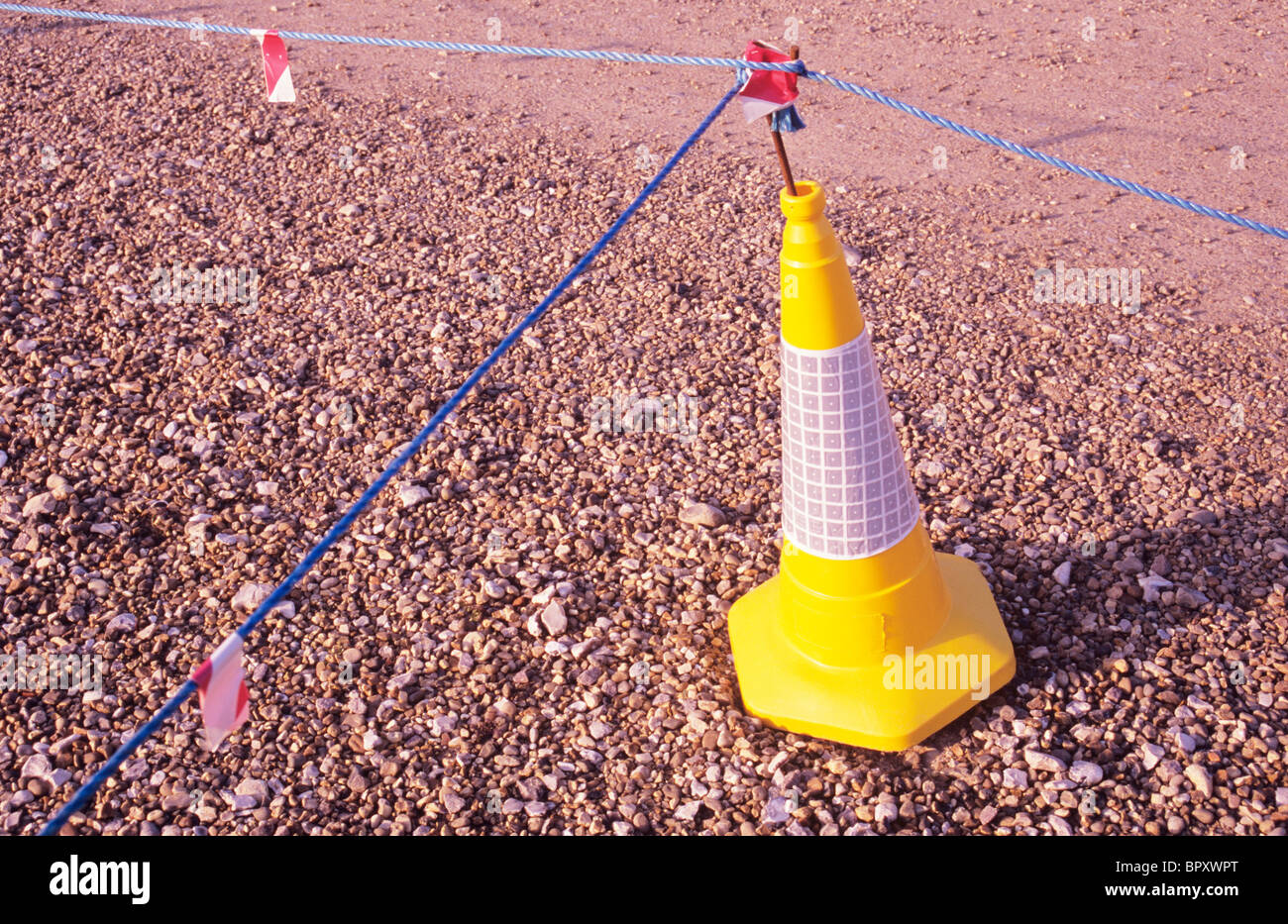 Traffico di colore giallo con cono blu corde di nylon che indica assenza di accesso o di parcheggio su area della superficie di ghiaia Foto Stock