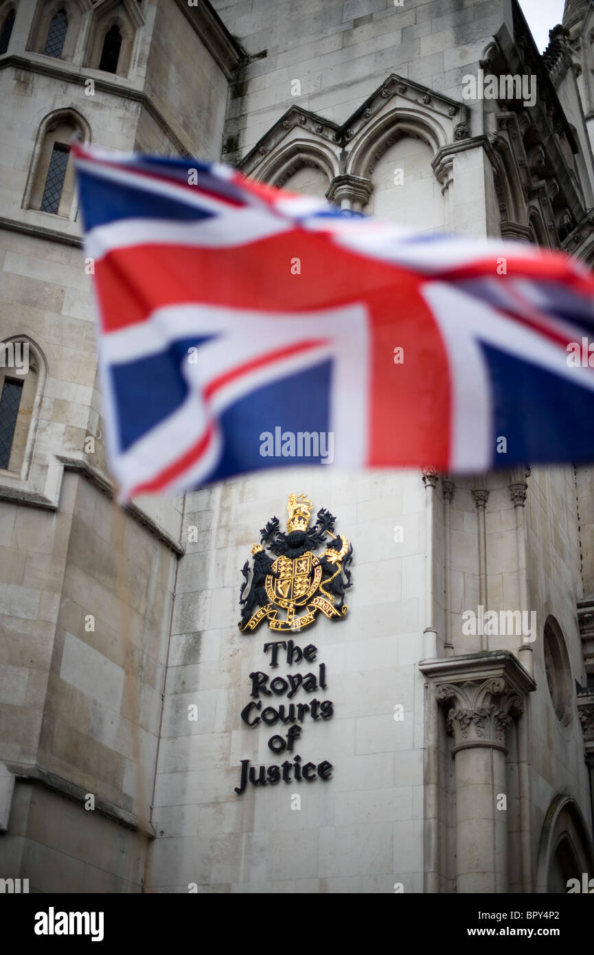 La giustizia britannica - Unione bandiera con la Royal Courts of Justice sign in background Foto Stock