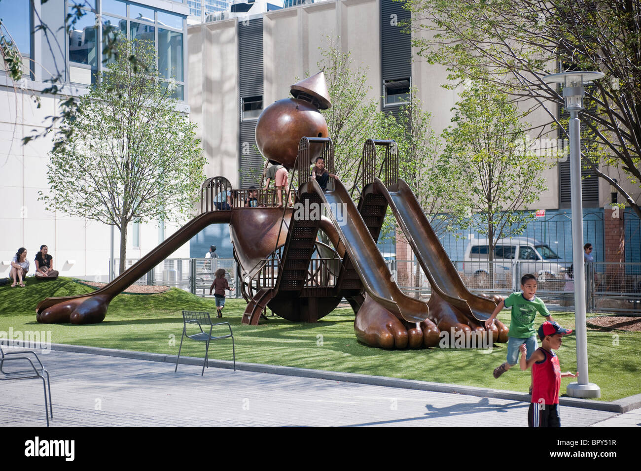 Un parco giochi in bronzo scultura dell'artista Tom Otterness, in un parco in torri di argento è un complesso di appartamenti a New York Foto Stock