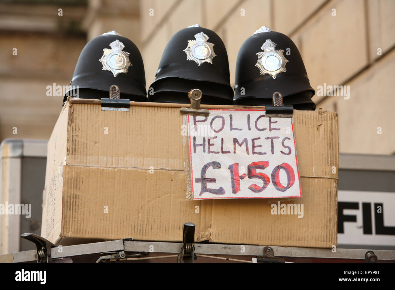 Toy Elmetti per Polizia su un dono bancarella vendendo souvenir di Londra e Inghilterra al lato della strada in Whitehall, Westminster, Lo Foto Stock