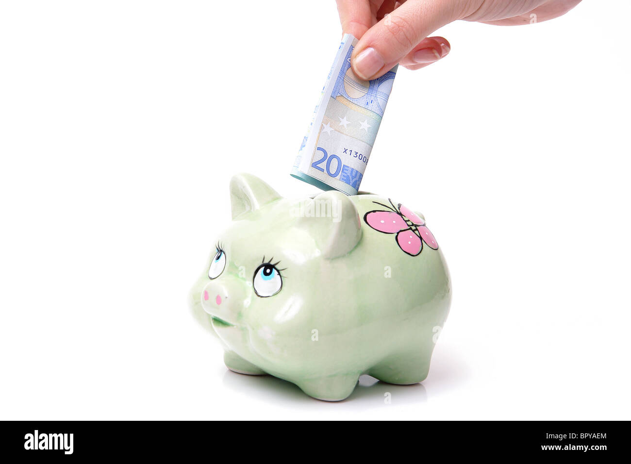 Donna mettendo un dollaro banconota in piggybank su sfondo bianco Foto Stock
