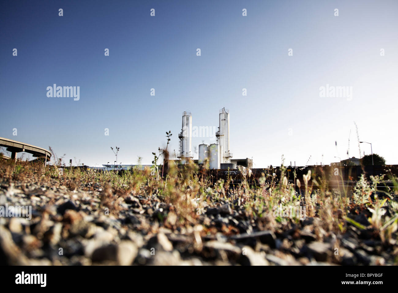 Paesaggio industriale con un impianto industriale e autostrada cavalcavia con cielo blu. Bassa angolazione della telecamera. Foto Stock