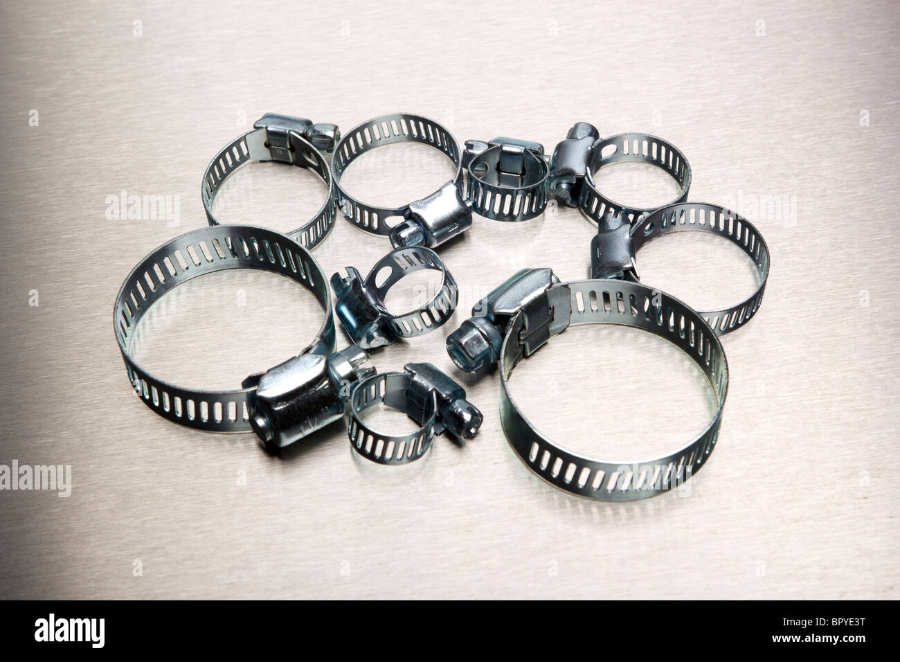 La fascetta del tubo flessibile di assortimento su sfondo in acciaio inox Foto Stock