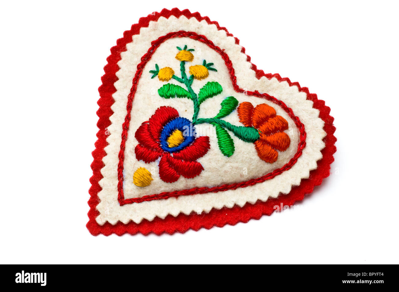 A forma di cuore ad ago cuscino decorato con ricamo ungherese isolato su bianco Foto Stock