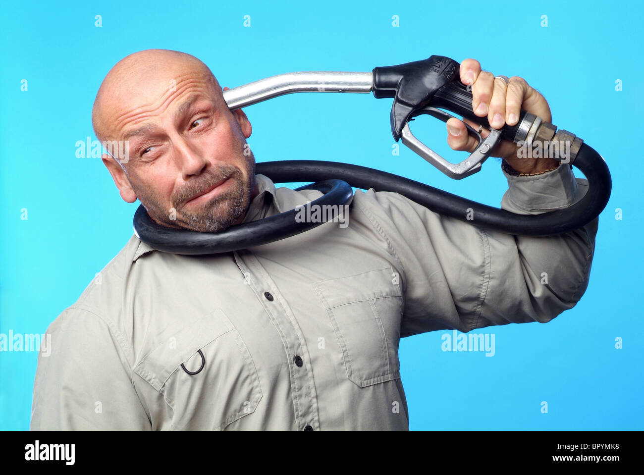 Uomo con un ugello di benzina contro la sua testa Foto Stock