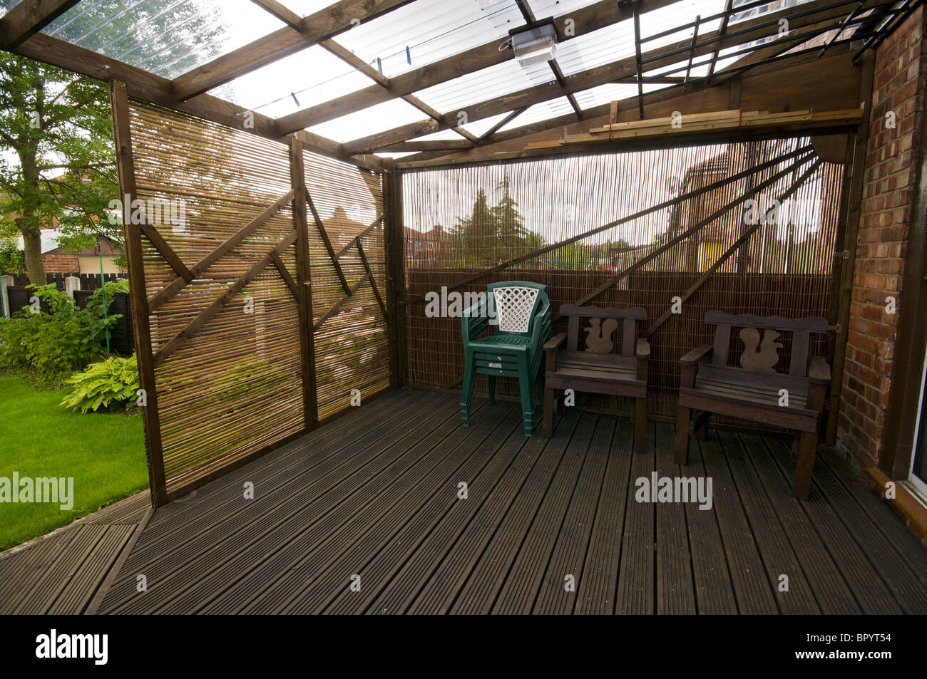 Casa costruita patio decking con plastica ondulata per tetti mobili e pannelli di screening in una impostazione interna. Manchester, Regno Unito. Foto Stock