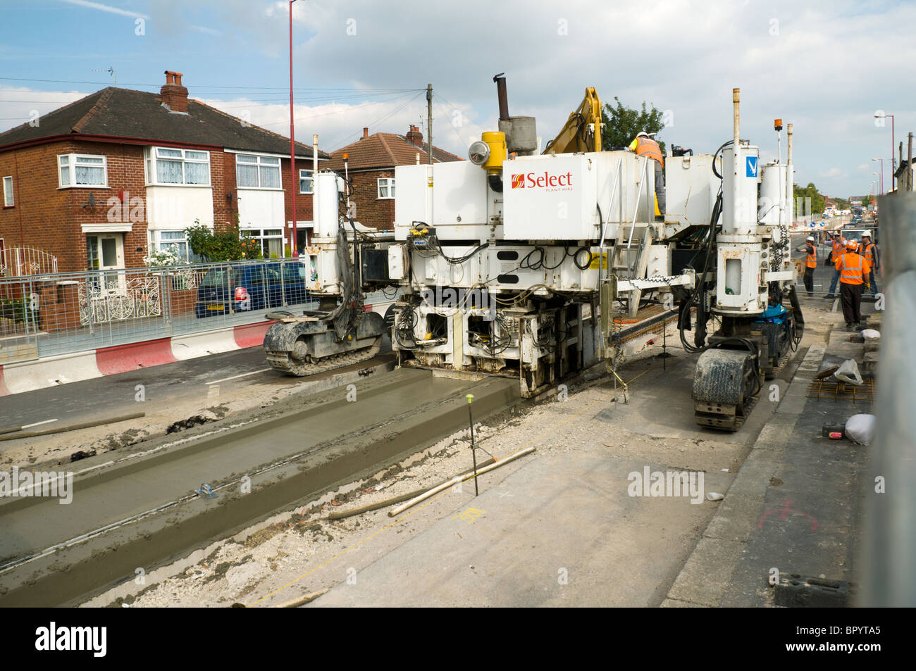 G&Z Slipform lastricatore cementificazione macchina al lavoro sul Manchester Metrolink (tram) progetto di costruzione, Tameside, England, Regno Unito Foto Stock