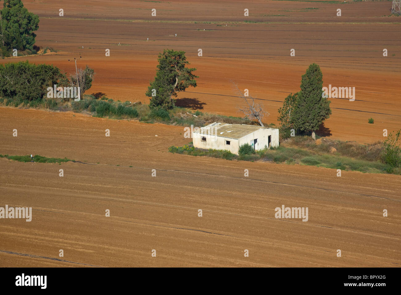 Vista astratta di una casa abbandonata in mezzo a un campo arato in Sharon Foto Stock