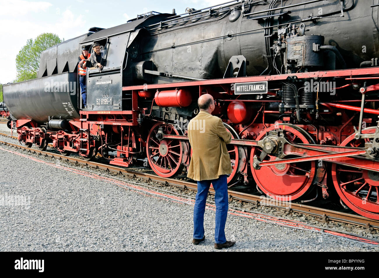 L'uomo ammirando locomotiva a vapore 'Mittelfranken' presso il tedesco della locomotiva a vapore Museum, Neuenmarkt, Franconia, Baviera, Germania. Foto Stock