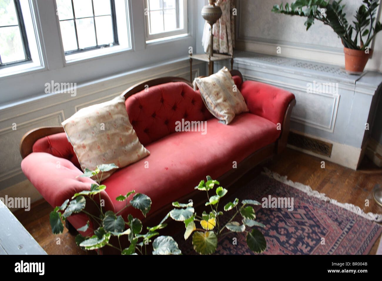 Vecchio retro vintage divano rosso luce della finestra Foto Stock