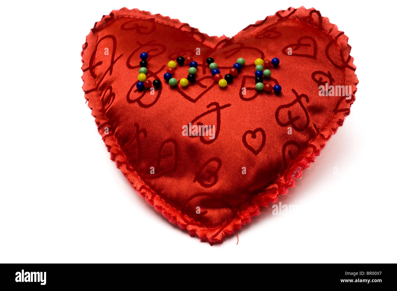Amore Inscripted con aghi su un cuore rosso isolato su bianco Foto Stock