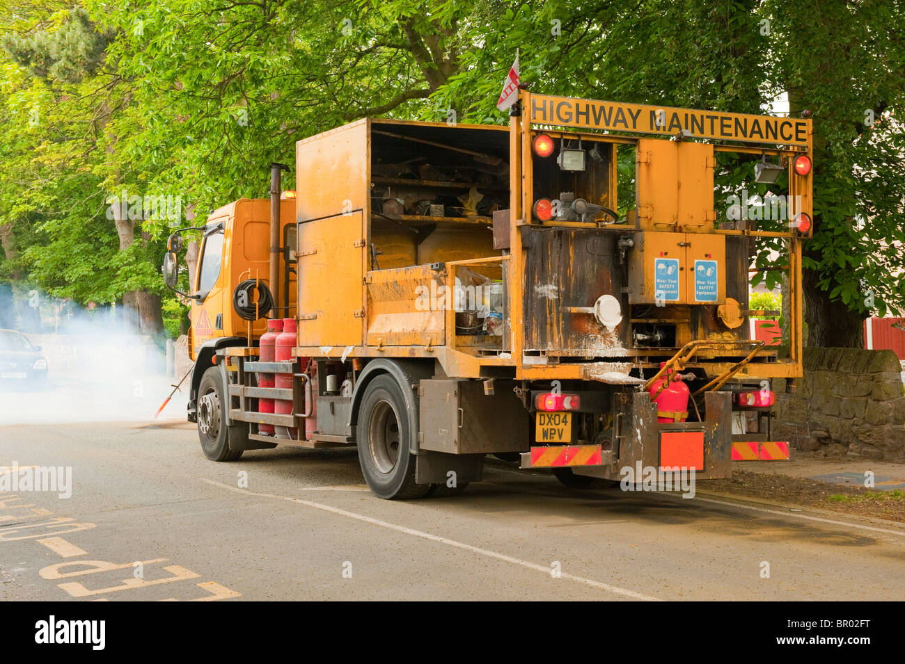 La segnaletica stradale le linee gialle essendo rimosso bruciando Foto Stock