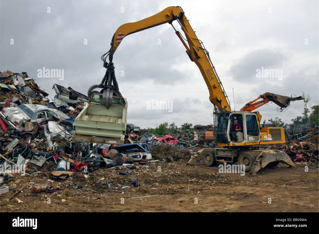 Auto viene scaricata su un palo in un metallo cantiere di scarto. Foto Stock