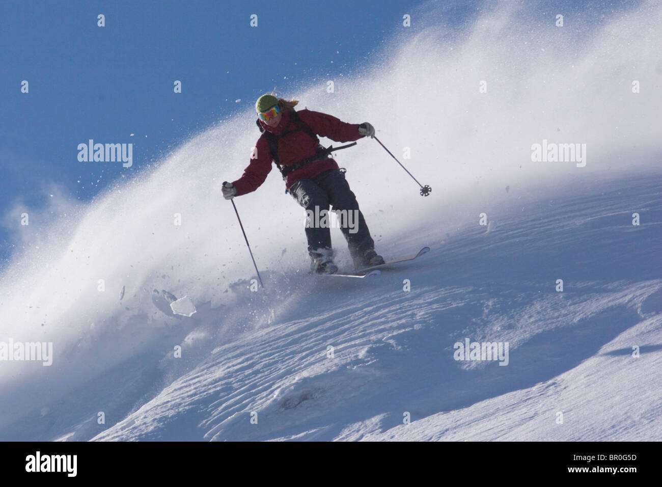 Una donna sci polvere di neve in una giornata ventosa sul vertice Donner in California. Foto Stock