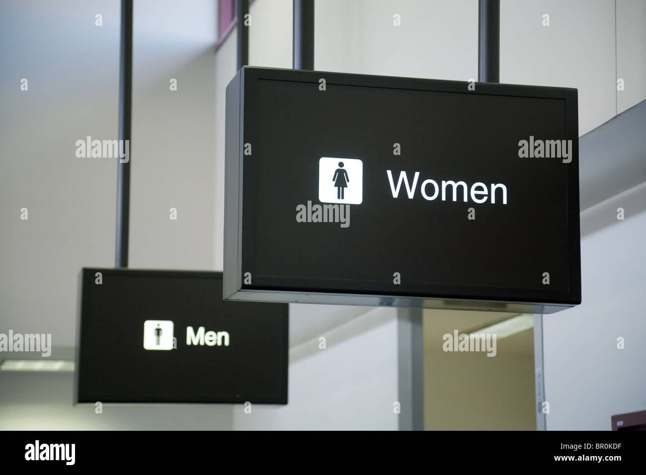 Segni per uomini e donne, bagni dell'aeroporto di Las Vegas; Nevada USA. Concetto le donne davanti agli uomini; le donne davanti agli uomini; gli uomini dietro le donne. Foto Stock