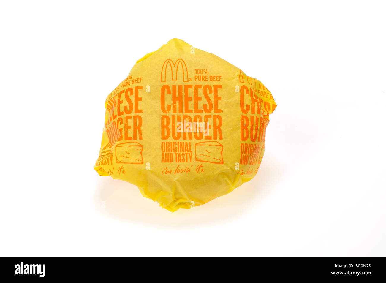 McDonald's Cheeseburger in involucro di carta il confezionamento su sfondo bianco, ritaglio. Foto Stock