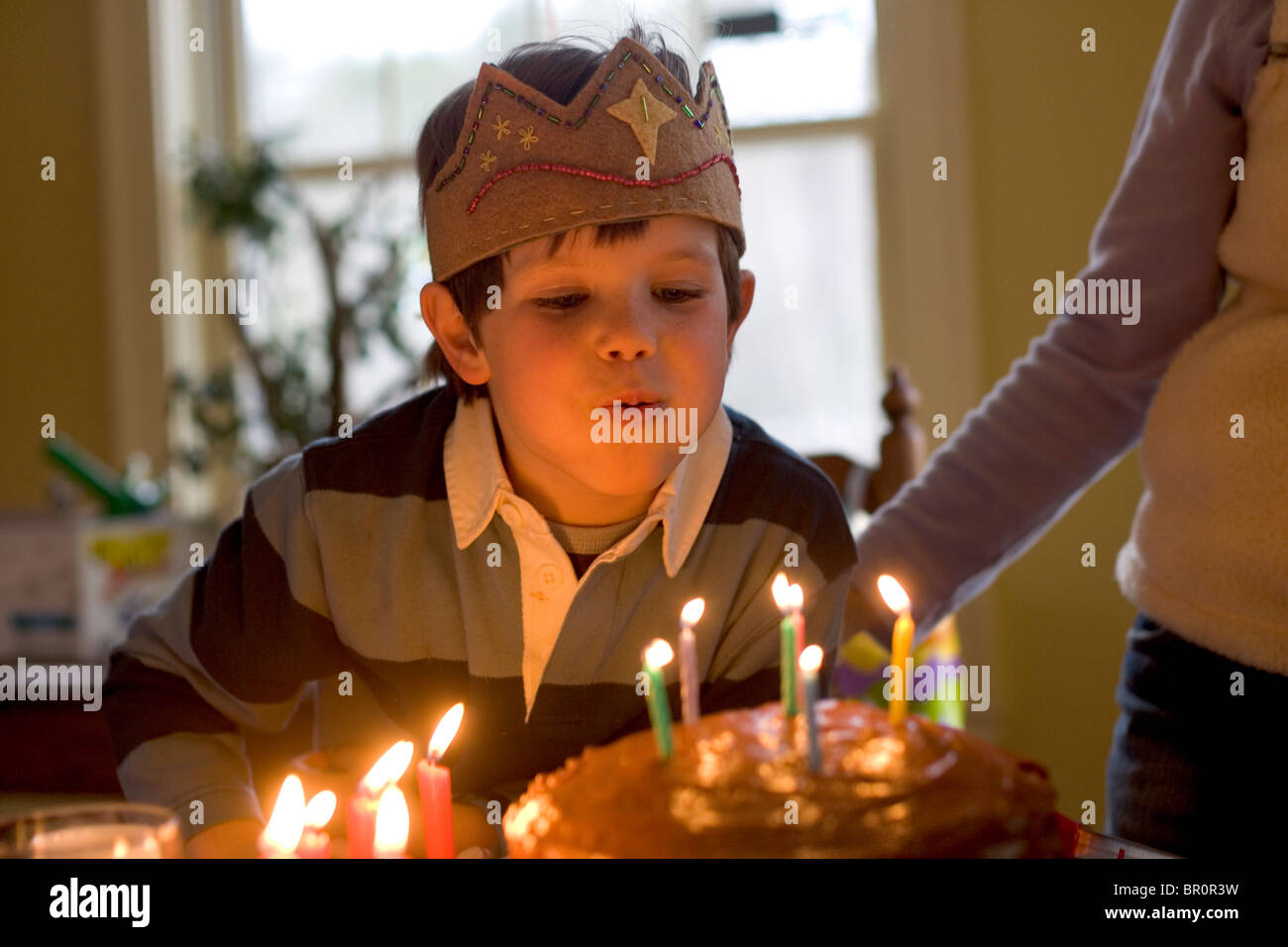 Un giovane ragazzo si brucia candele e celebra il suo sesto compleanno a casa sua a Yarmouth, Maine. Foto Stock