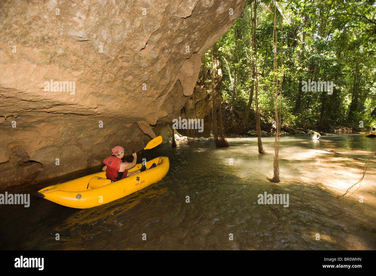 Un gruppo di turisti di avventura attraversando quattro caverne in rafting e kayak sul ramo di grotte fiume nel centro di Belize. Foto Stock