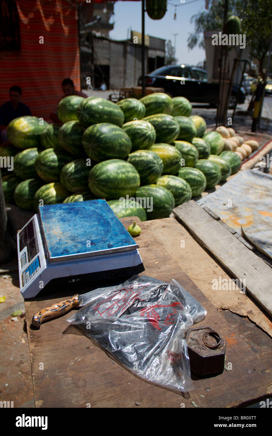 Gli uomini la vendita di acqua di melone alla successiva rotonda come si immette Yarmouk camp palestinese a Damasco Foto Stock