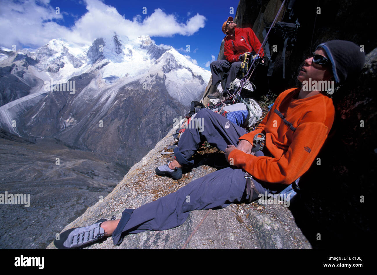 Un uomo e un giovane maschio in appoggio su una battuta mentre alpinismo nella Cordillera Blanca, Perù. Foto Stock