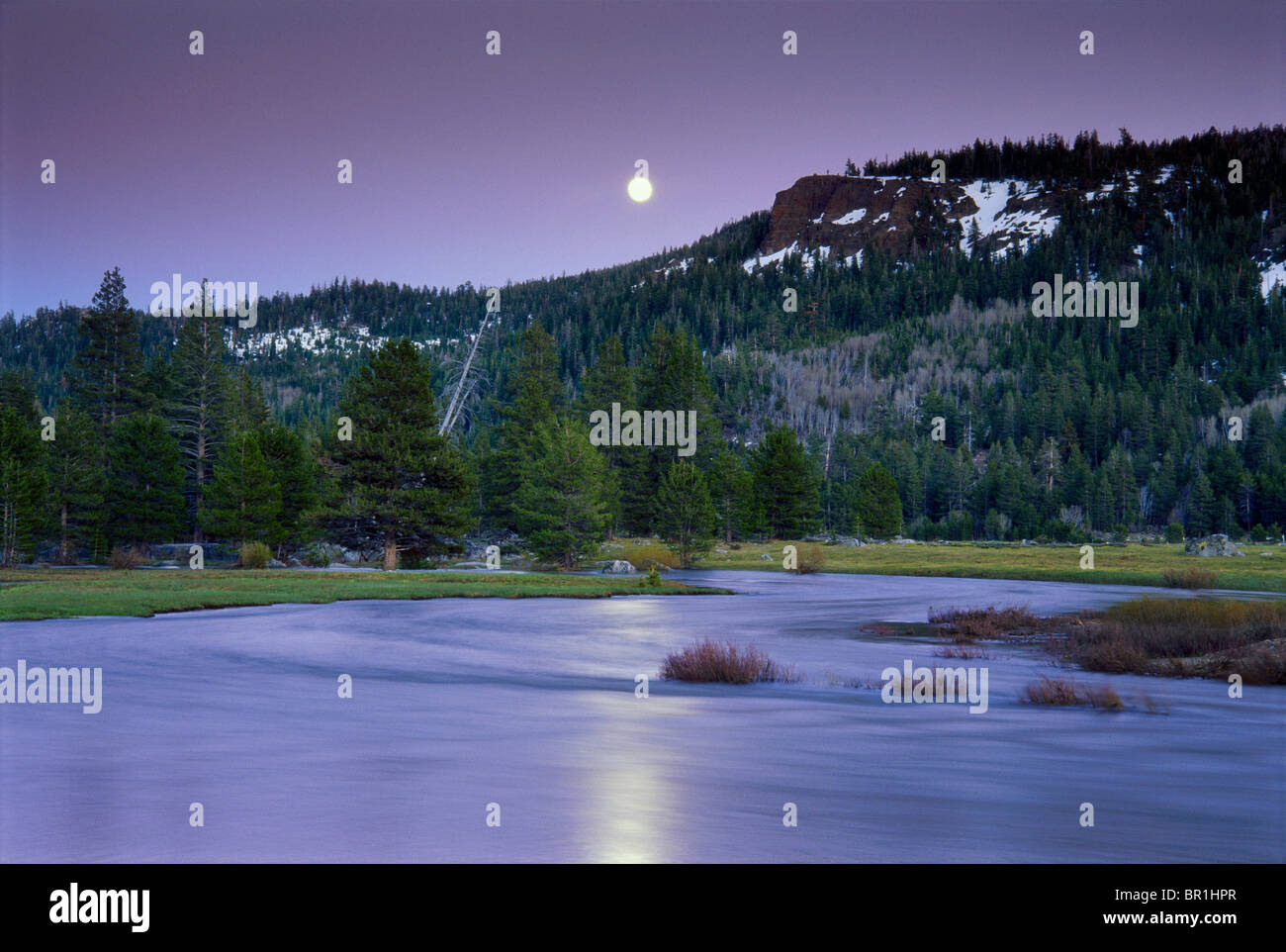 Luna crescente oltre il fiume di montagna valle Foto Stock