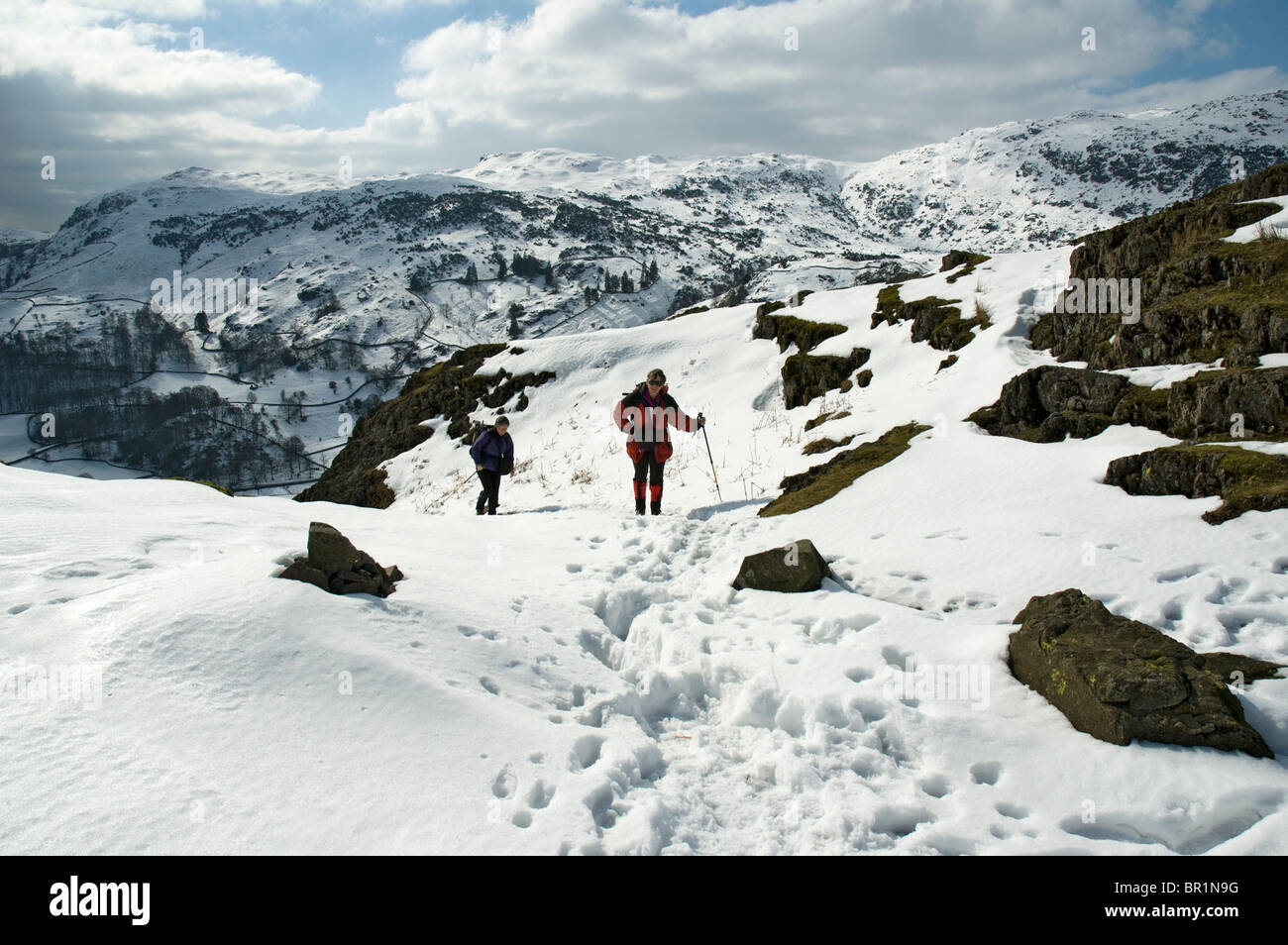 Hill walkers sul timone roccioso in inverno, Easedale, vicino a Grasmere, Lake District, Cumbria, England, Regno Unito Foto Stock