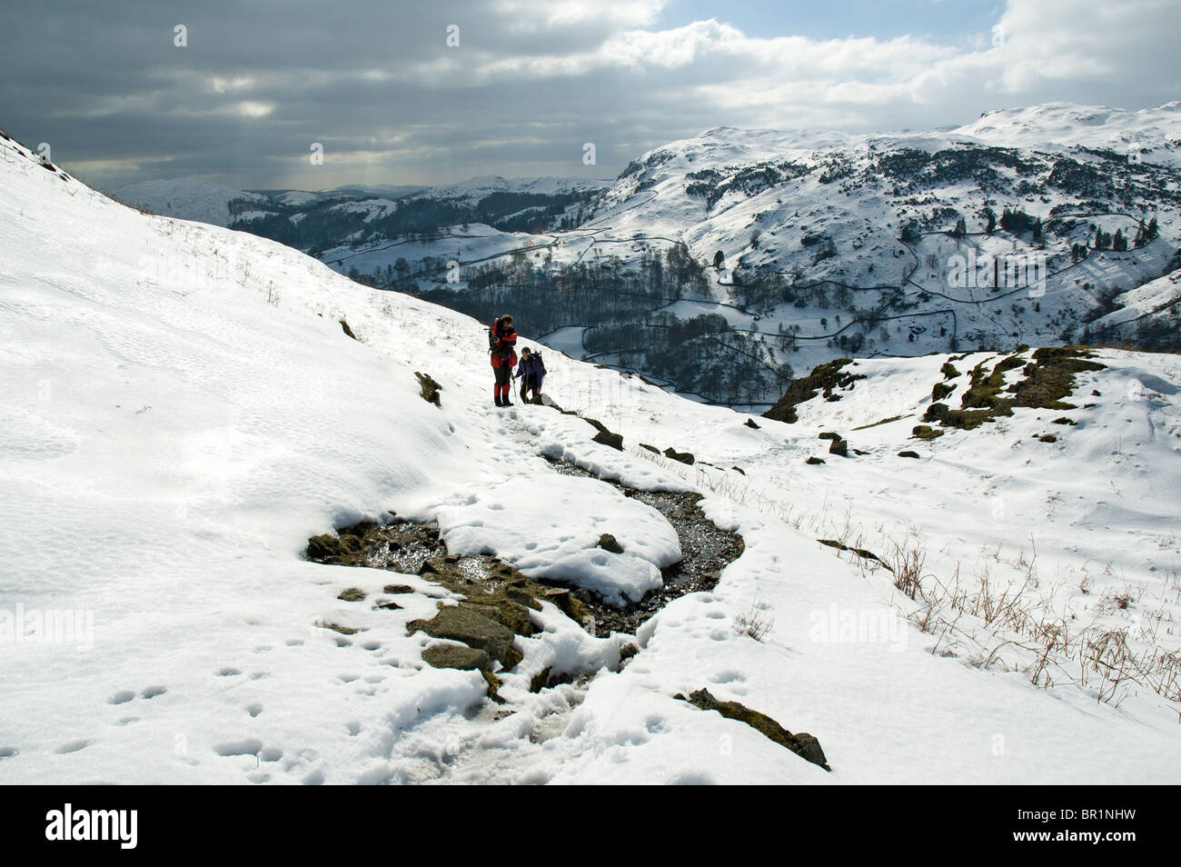 Hill walkers sul timone roccioso in inverno, Easedale, vicino a Grasmere, Lake District, Cumbria, England, Regno Unito Foto Stock
