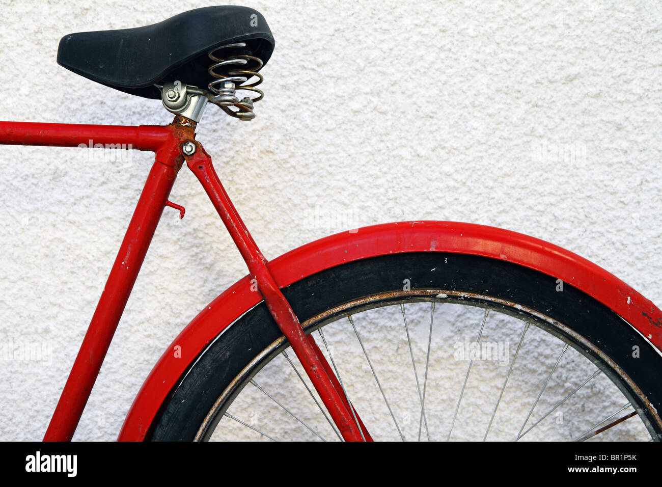 Parte posteriore della vecchia bicicletta rossa appoggiata contro la parete dipinta di bianco, Kas, Turchia (sezione anteriore BR1NHE) Foto Stock