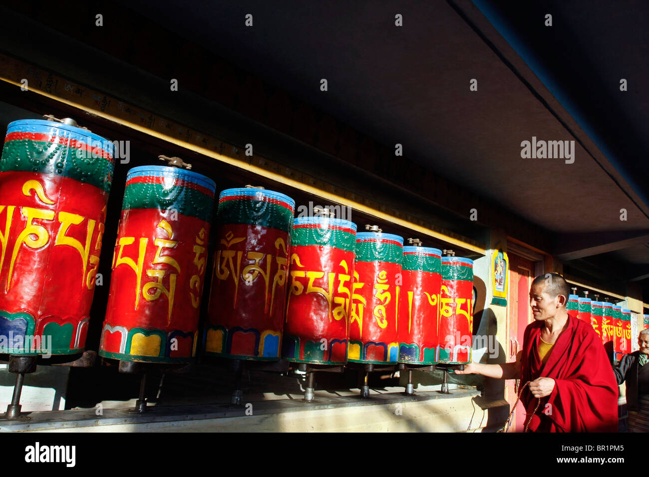 Buddisti Tibetani il culto a un tempio mediante filatura ruote della preghiera in McLeod Ganj Dharamsala in Himachal Pradesh in India. Foto Stock