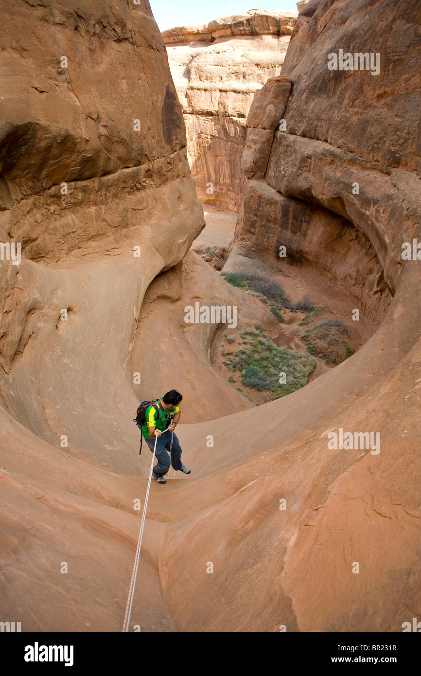 L'uomo rappelling nel canyon, il Parco Nazionale di Arches, Utah Foto Stock