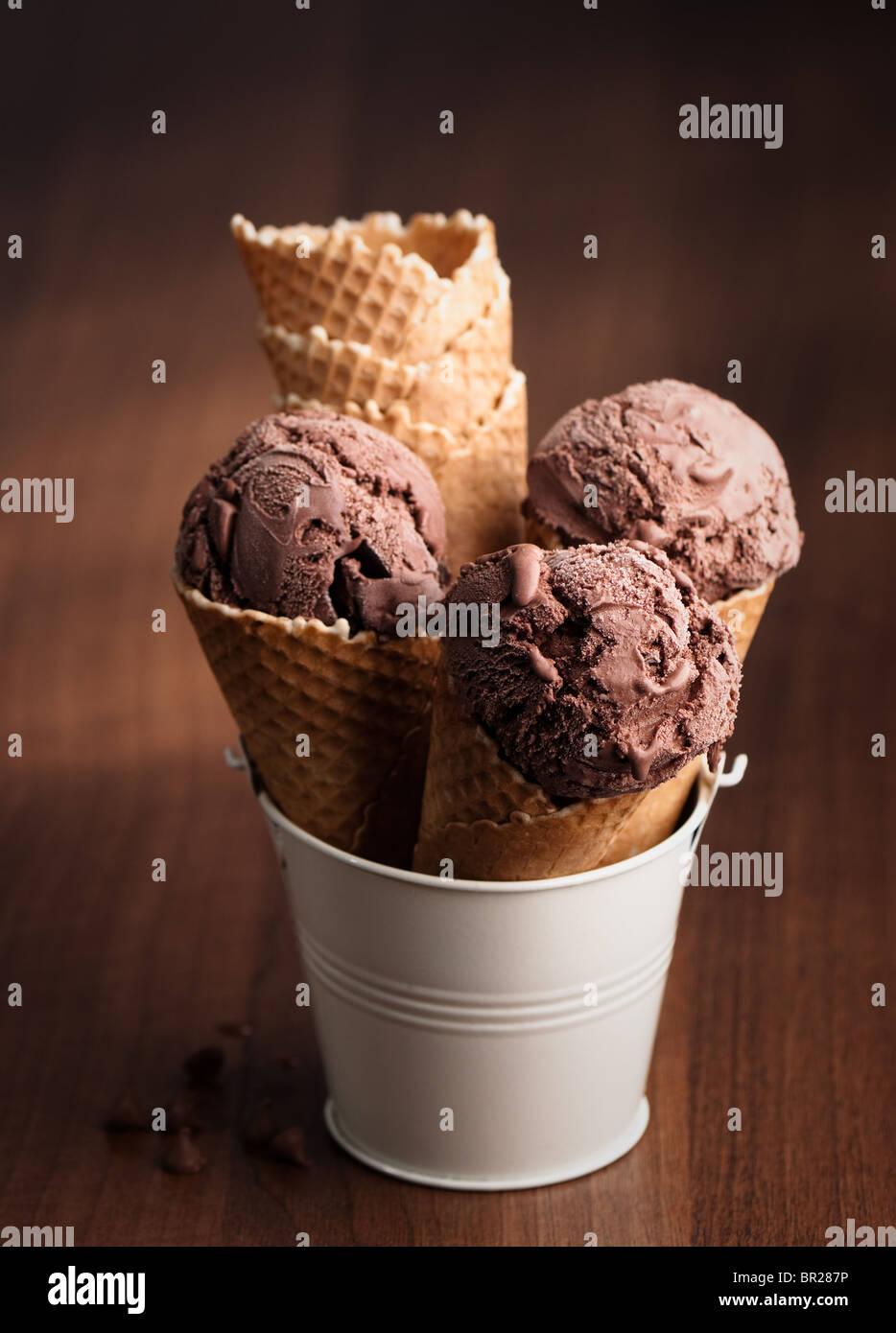 Gelato al cioccolato in coni in piedi in color crema benna in metallo Foto Stock