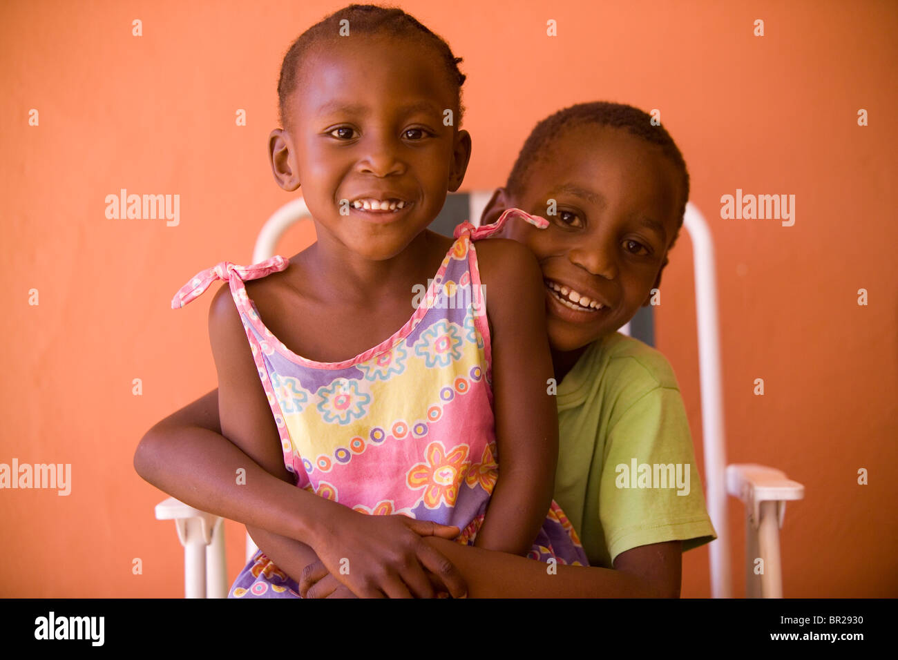 Un giovane ragazzo mantiene la sua sorella più piccola sul suo giro a Gaborone, in Botswana. Foto Stock