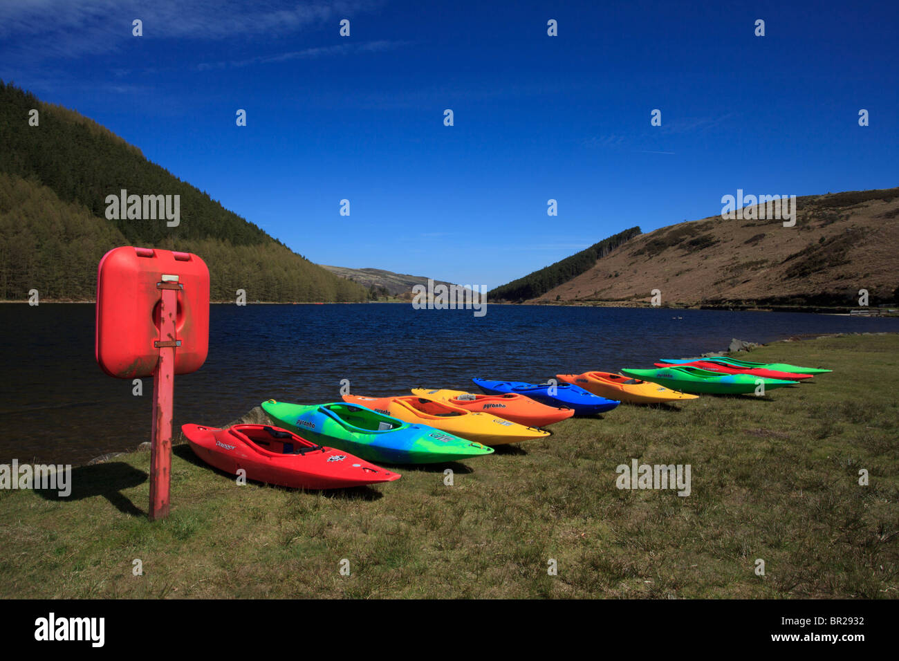 Canoe colorate sulla riva di un lago tranquillo. Foto Stock