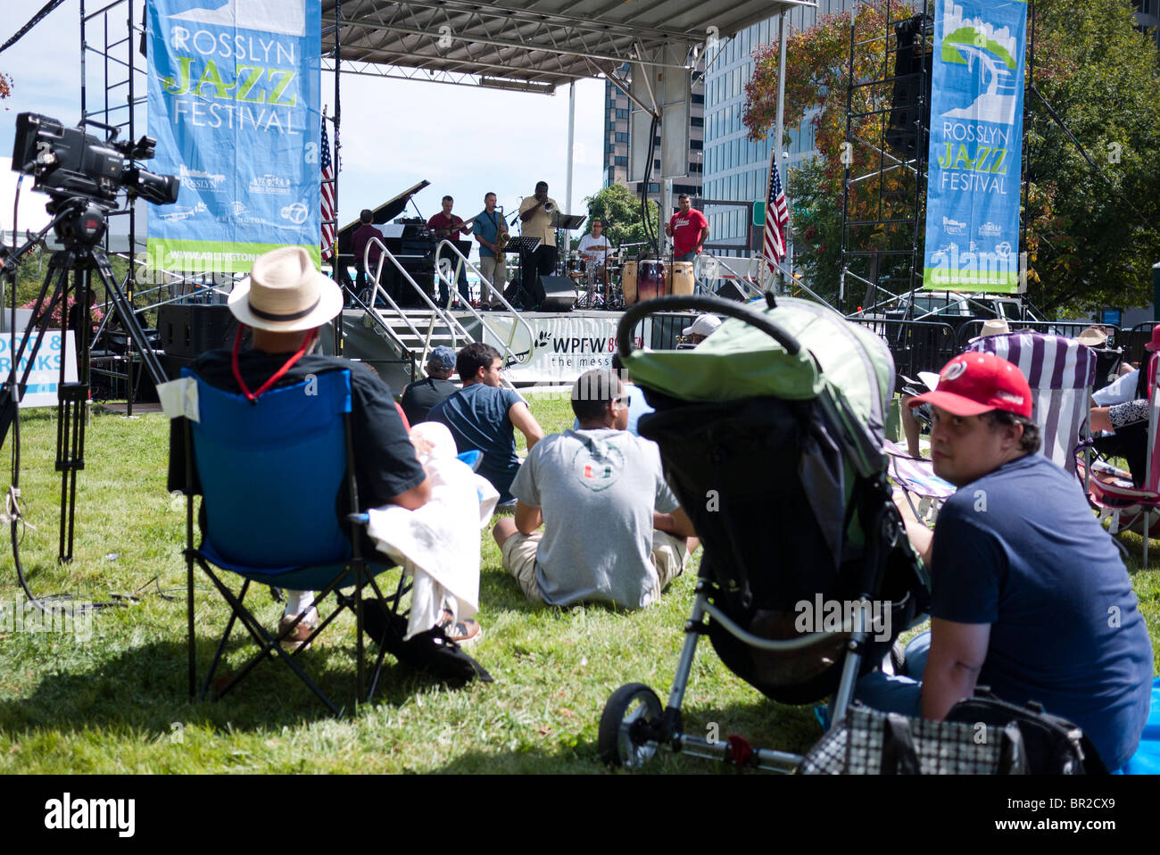 Rosslyn Jazz Festival Arlington Virginia // ARLINGTON, Virginia - gli spettatori si riuniscono sull'erba per godersi il ventesimo Rosslyn Jazz Festival, che si tiene nel 2010 a Rosslyn, un vivace quartiere della contea di Arlington. Una band jazz si esibisce su un palco all'aperto sotto il cielo limpido, offrendo intrattenimento ai partecipanti. Foto Stock