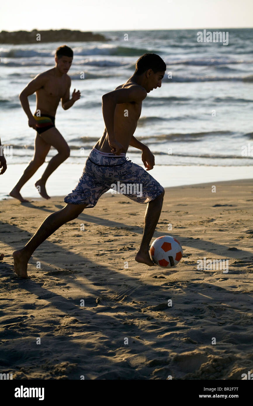 Ragazzi giocare a calcio sulla spiaggia di Tel Aviv, Israele Foto Stock