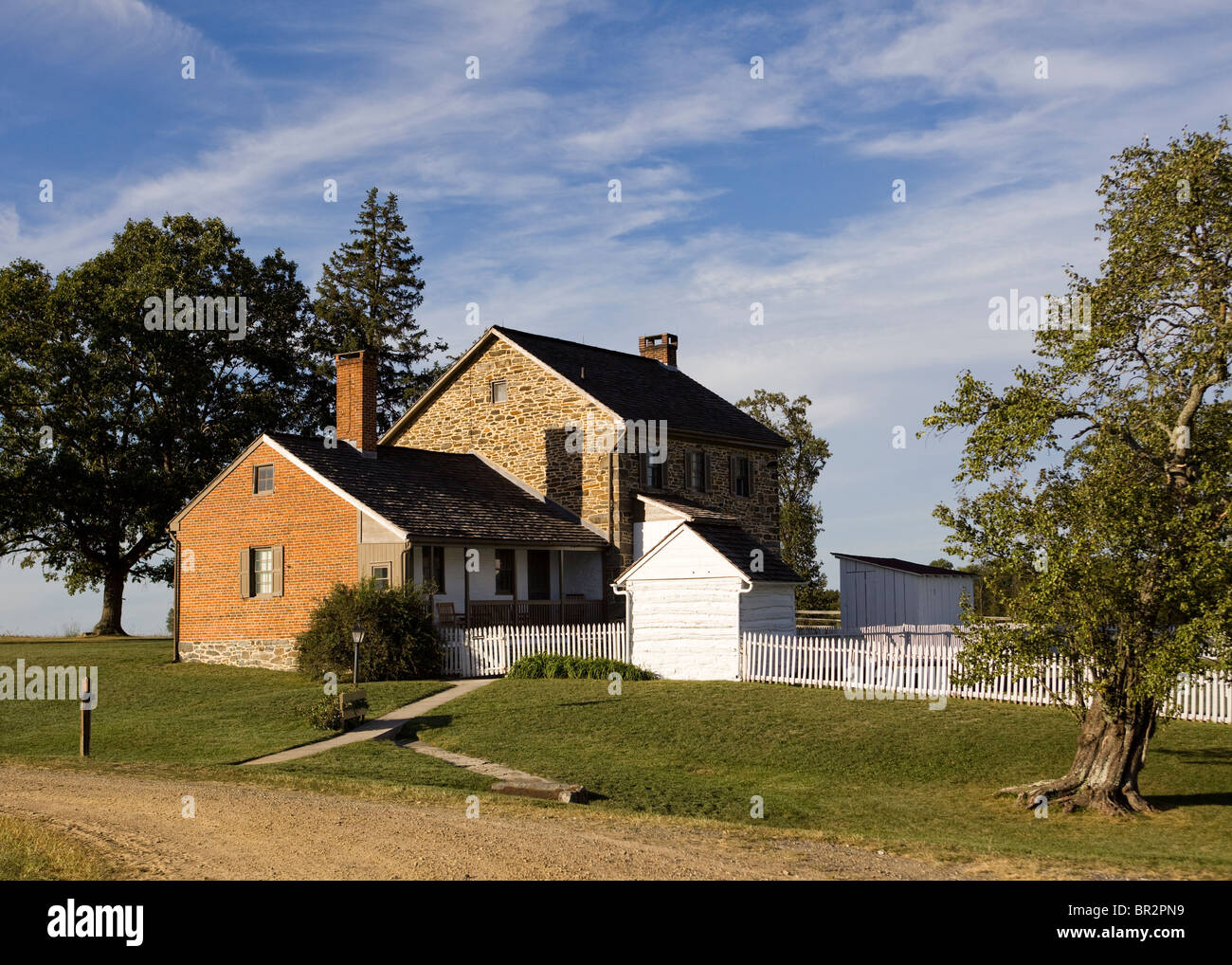 Mattone di vecchia casa di pietra con il bianco picket fence - Virginia STATI UNITI D'AMERICA Foto Stock
