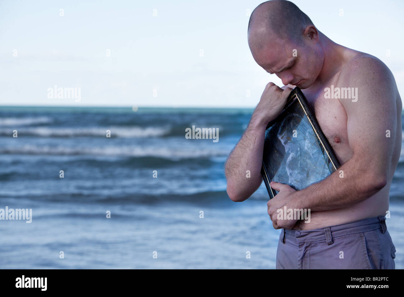 Un uomo abbraccia una vecchia foto Foto Stock