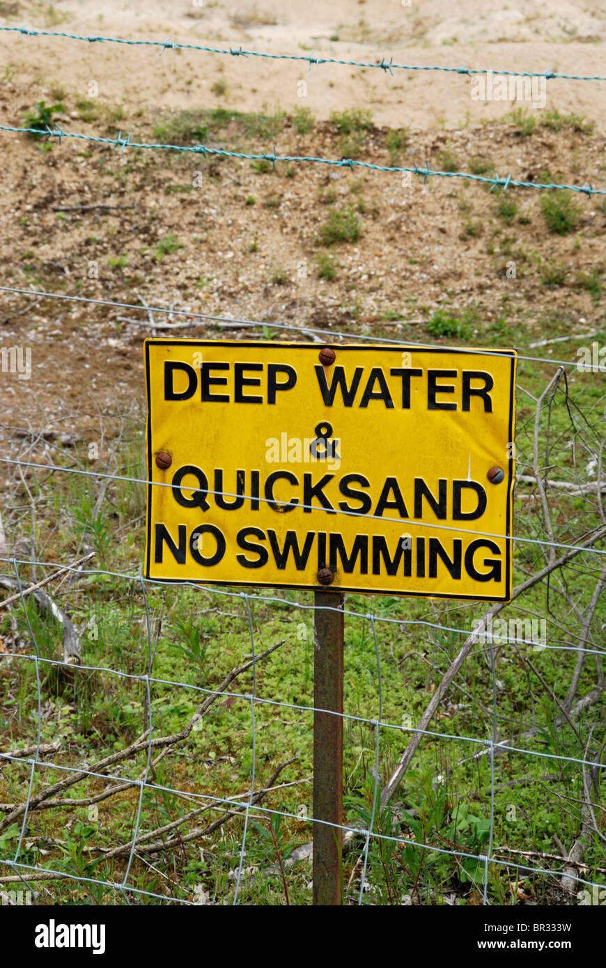 'Deep acqua e sabbie mobili - No Nuoto' segno su una recinzione Foto Stock