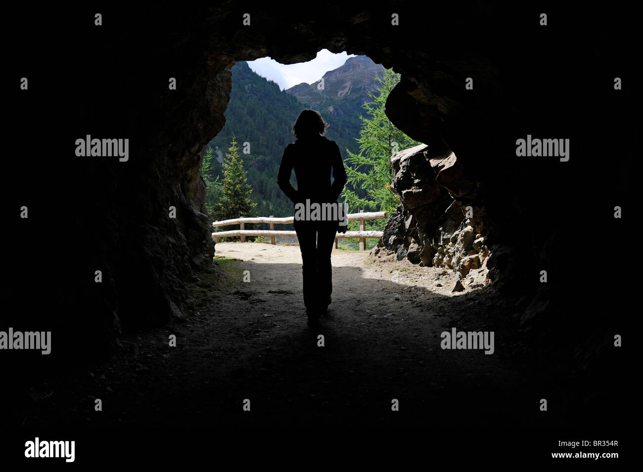 La donna a piedi attraverso un tunnel nelle alpi. Foto Stock
