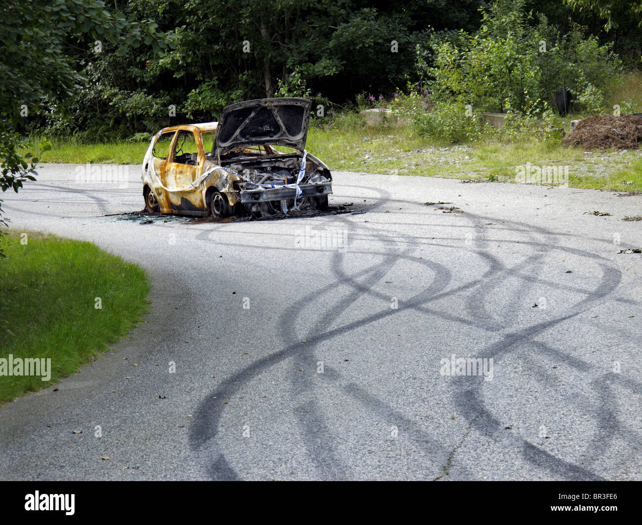 Un vandalizzato e bruciato auto a sinistra sulla strada dopo wild la guida. A Göteborg il sobborgo, Svezia. Foto Stock